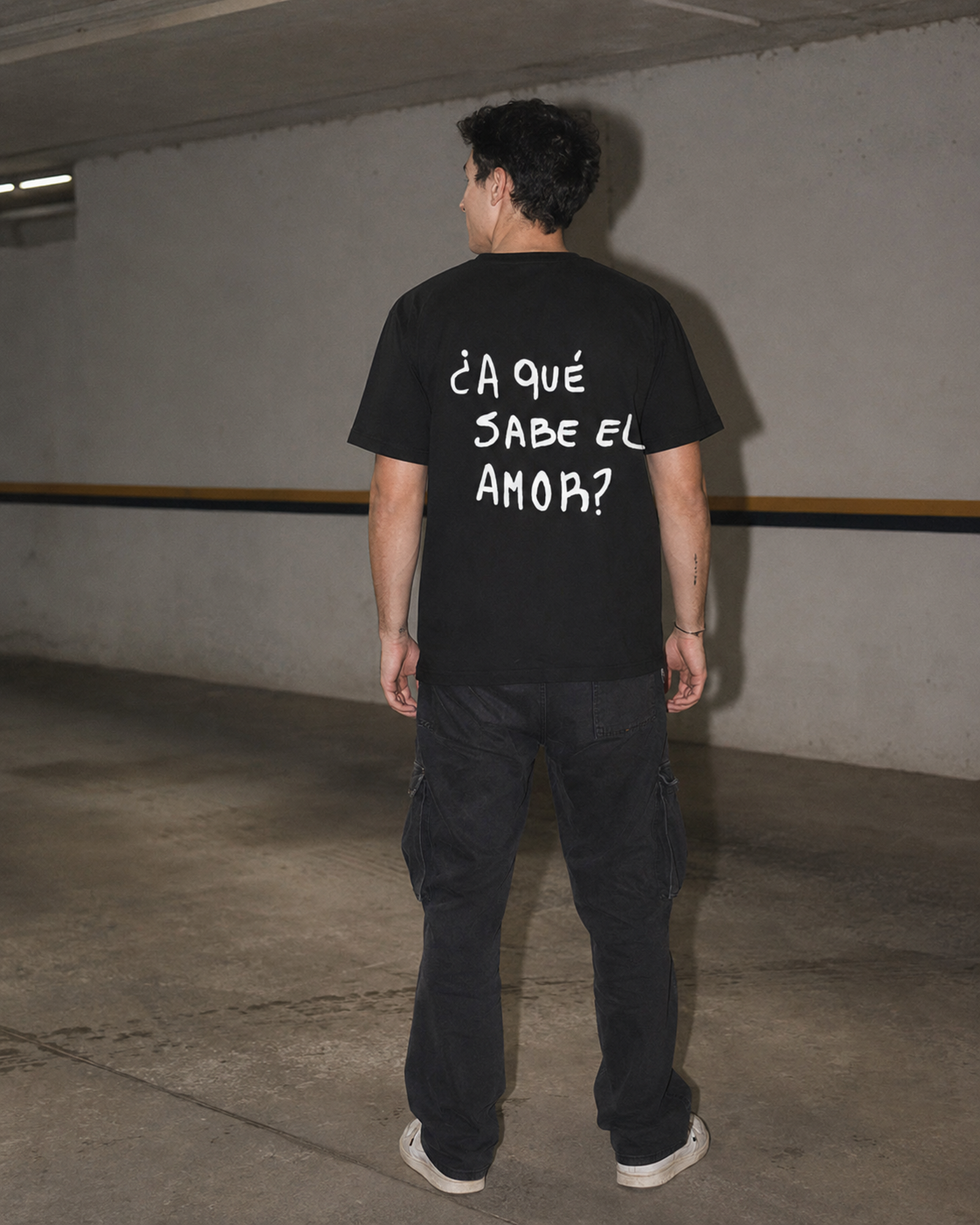 Remera clásica negra con la frase A qué sabe el amor estampada en la espalda.